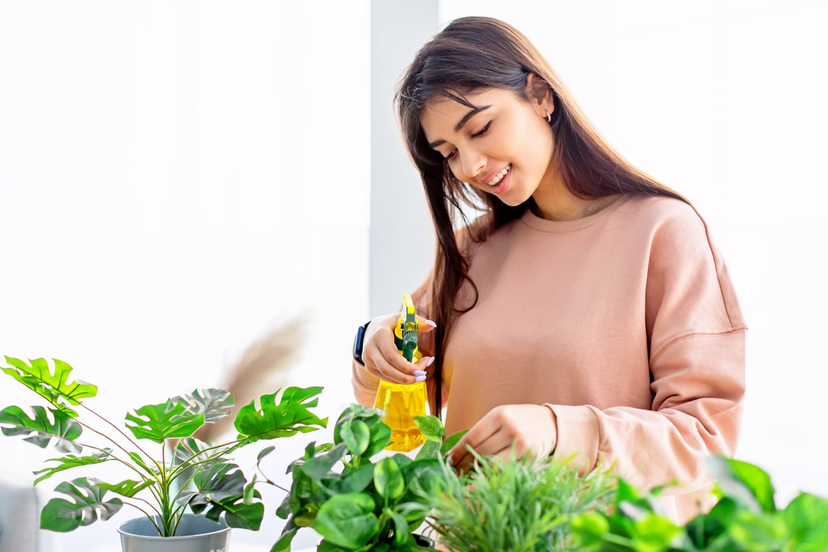 Femme arrosant ses plantes avec du liquide