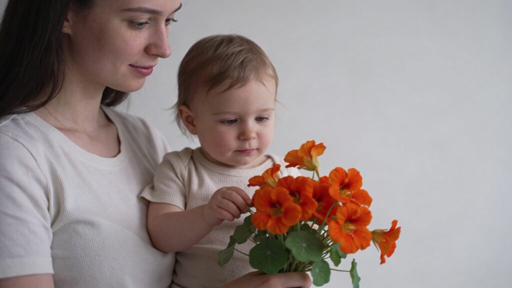 Jeune mere tenant bouquet de capucines orange