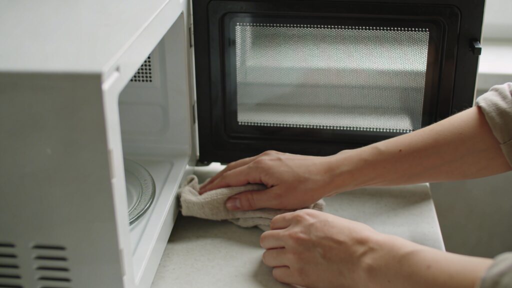 Personne essuyant interieur de micro ondes porte ouverte